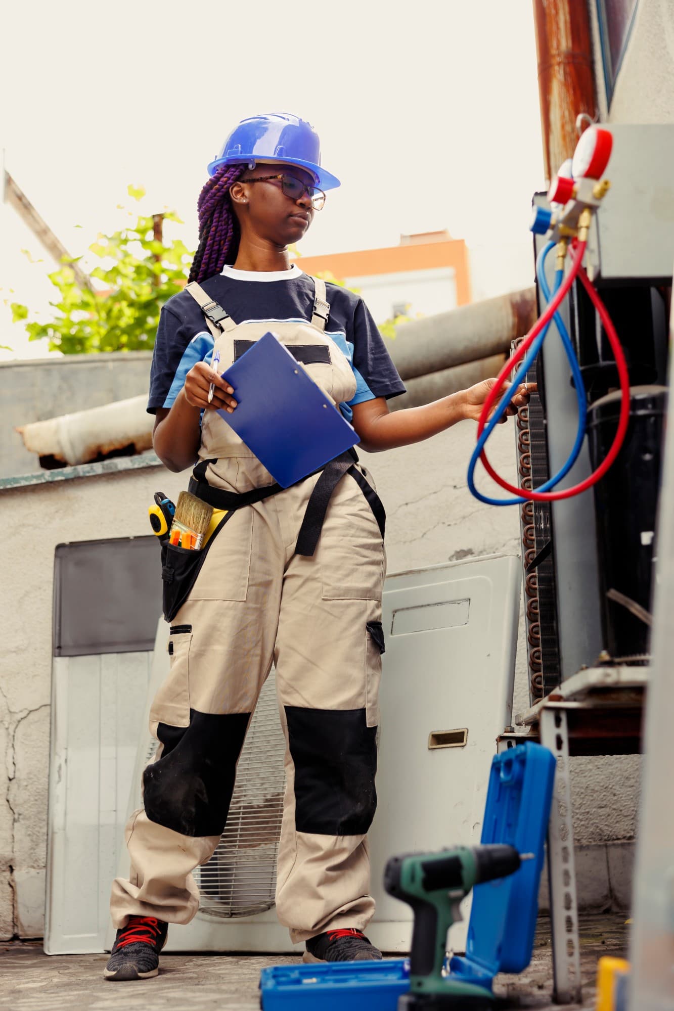 Técnica de capacete azul a verificar um equipamento, com prancheta na mão